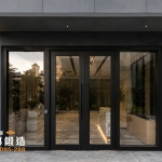 AI 模擬示意圖：正邦鍛造C9B-4006 社區大廈 社區大樓大廳雙開門 社區玻璃大門 現代別墅，深灰色水泥板外牆設計