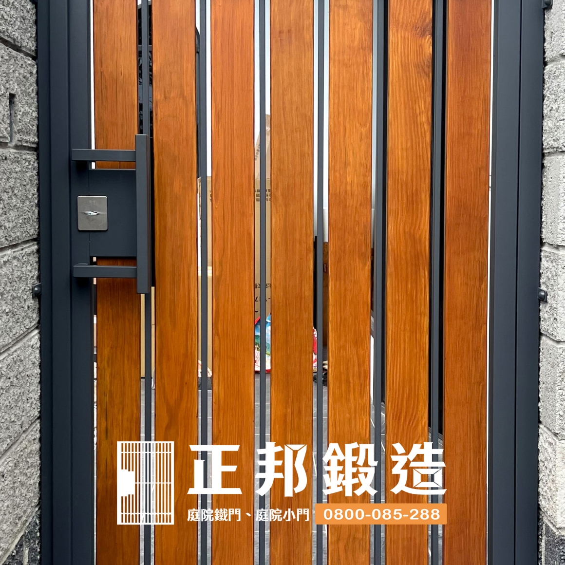 頭份不鏽鋼庭院門實際完工照片，FR-2910M1深灰烤漆框架搭配橡木色南方松直向木條，透過深色金屬與天然木材的冷暖對比，降低庭院大門厚重感並與灰色石材門柱及住宅外觀協調