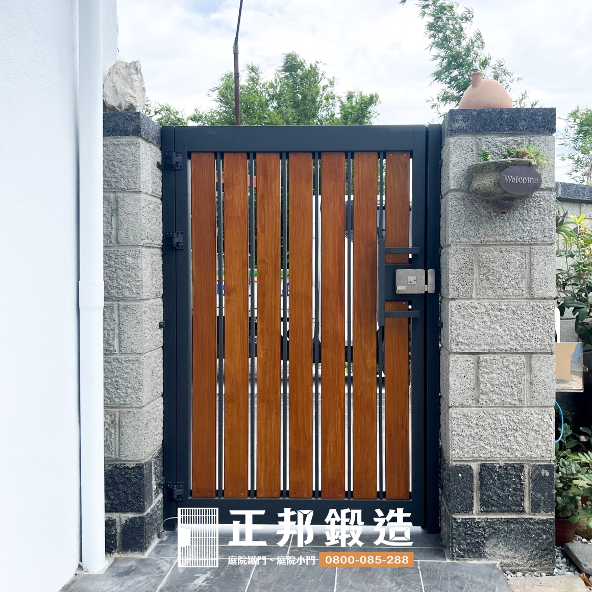 苗栗頭份不鏽鋼庭院門完工細節，深灰FR-2910M1烤漆金屬框架搭配直向橡木色南方松木條，透過清楚的金屬線條與天然木紋形成材質對比，適合希望兼顧現代感與住宅溫度的透天庭院入口