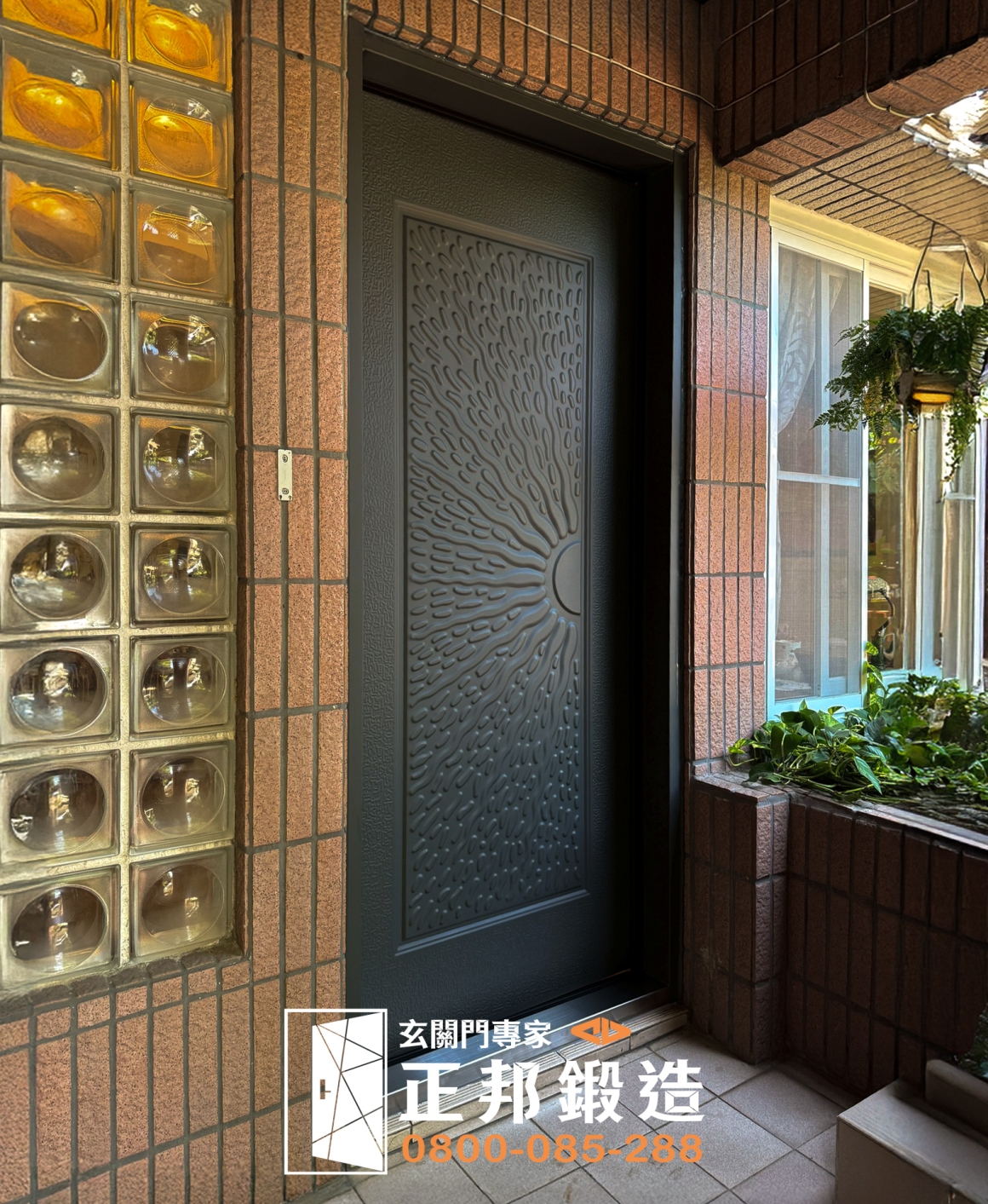正邦高雄大門完工實拍，老屋原有綠色大門更新為深色立體造型單開玄關門，包框施工完成後與原有紅色磁磚牆、玻璃磚及住宅入口自然銜接，呈現高雄老屋換門完成後的外側整體效果。