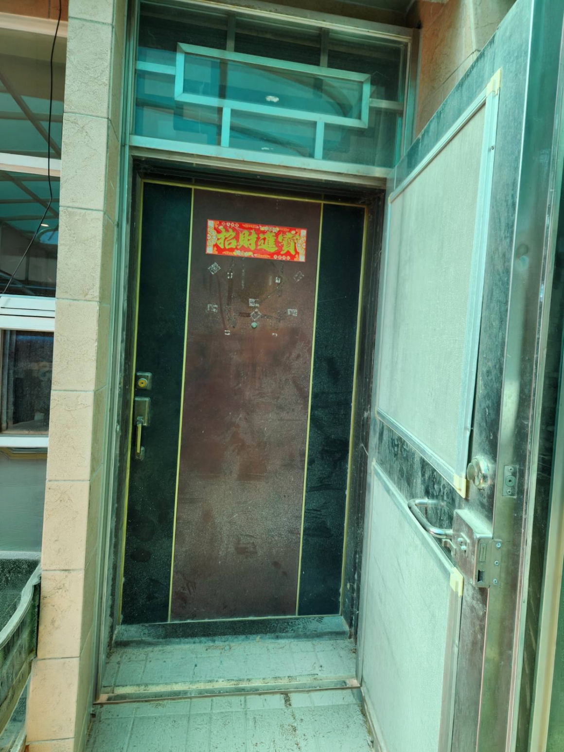 台中大門廠商正邦鍛造施工前現勘照片，透天住宅原有外玄關門、內玄關門與上方開天完整保留在同一入口，師傅於包框換門規劃前確認雙門配置、既有框體、門檻與門洞條件。