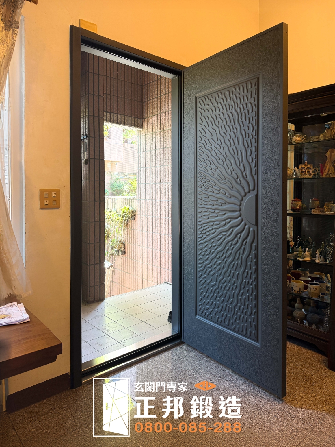 正邦高雄包框換門案例完工後開門狀態實拍，從室內可看到新玄關門開啟後的門洞、包框收邊及門檻配置，呈現高雄老屋大門從現勘、舊框鏽蝕評估到完成新門安裝後的實際使用狀態。