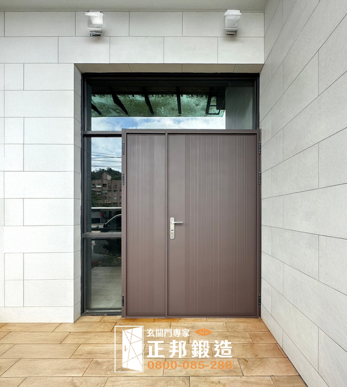 基隆老舊大門換新完工案例，正邦以包框換門方式安裝C9B-2058子母門，搭配FR-8677烤漆色，保留既有建築門洞與周邊玻璃配置，同時更新門框、門檻與門扇。