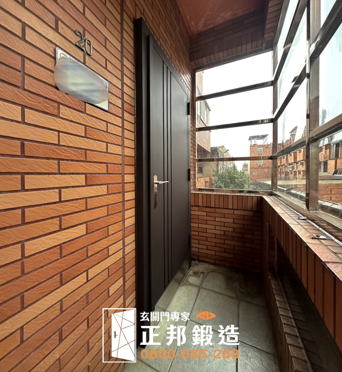 正邦鍛造桃園新屋 C9B-2040 玄關門完工實景，FR-8679 深色粉體烤漆搭配紅磚住宅外牆，門框、門檻與門扇依本案需求採不鏽鋼材質製作，外觀仍維持現代玄關門的簡潔質感。