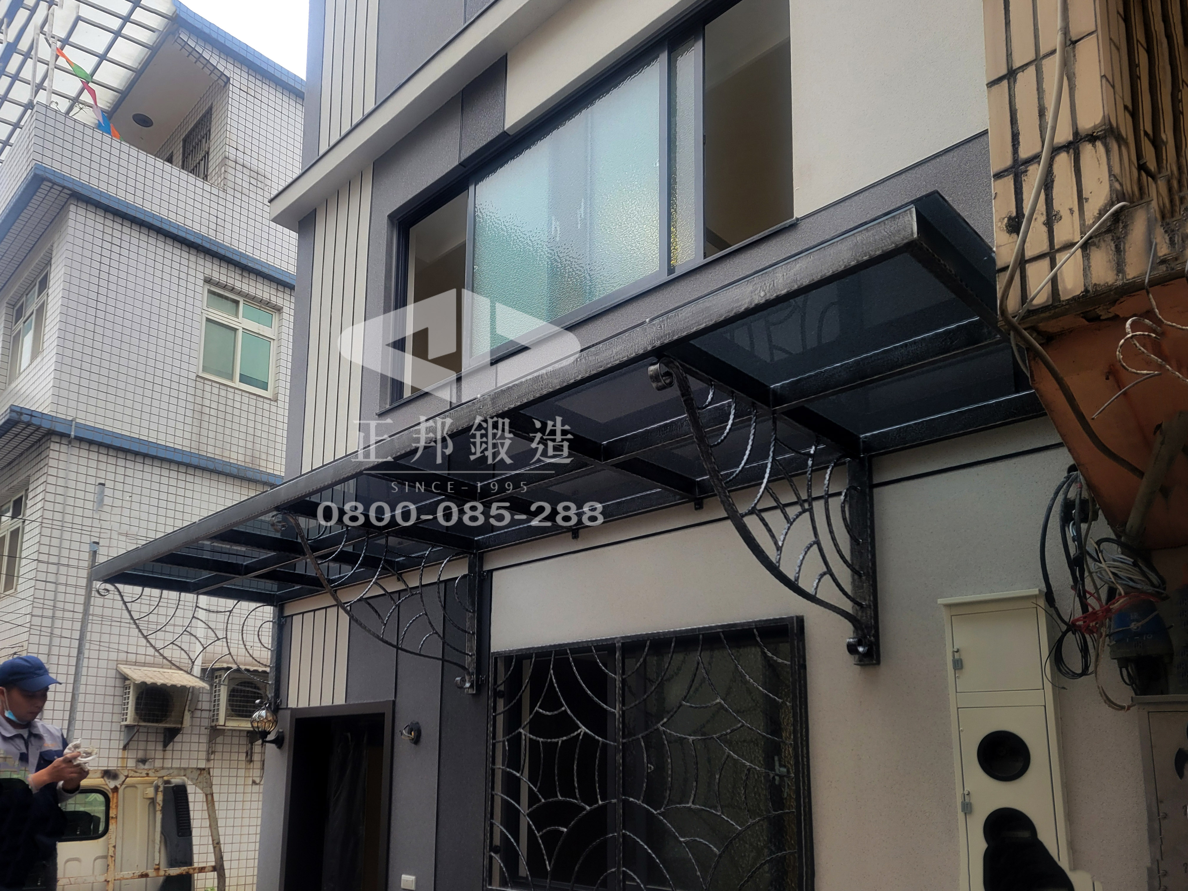 正邦鍛造銀灰色歐式簡約遮雨棚，提供一站式鐵件設計服務，可訂製鐵窗、大門、欄杆，確保建築風格與遮雨棚結構耐久性一致。